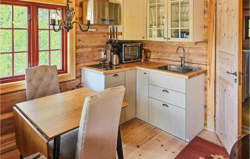 a kitchen with a table and a wooden wall at Beautiful Home In Sr-fron With House A Mountain View in Kvitfjell