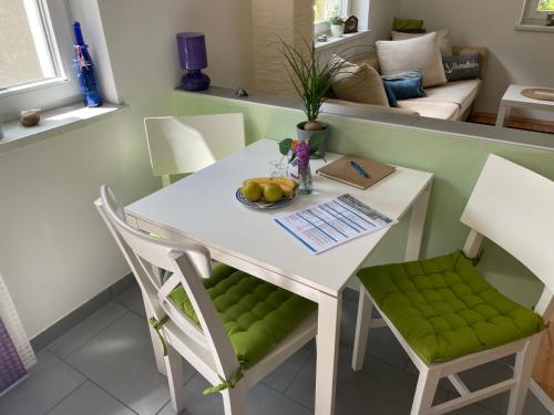 - une table et des chaises blanches avec un bol de fruits dans l'établissement Ferienwohnung LISL, à Obervellach