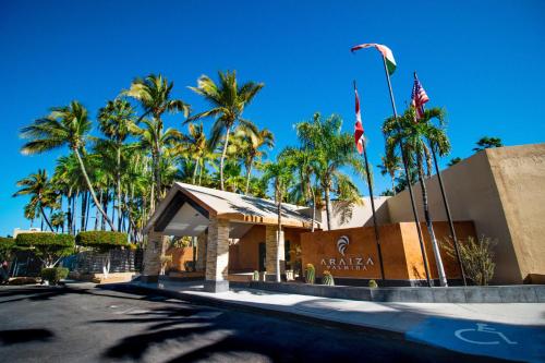 a building with palm trees and flags in front of it at Araiza Palmira Hotel y Centro de Convenciones in La Paz