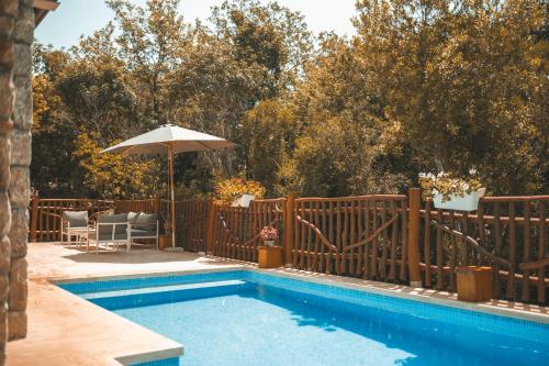 a swimming pool with a fence and an umbrella at Resort & Villas Carević in Budva