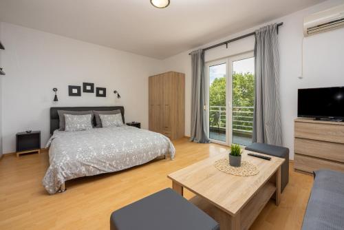 Schlafzimmer mit einem Bett, einem TV und einem Tisch in der Unterkunft Apartments Claudia in Crikvenica