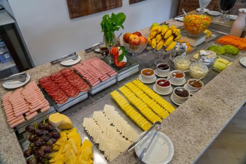 a buffet of food with cheese and fruit on a table at Pousada dos Sonhos in Florianópolis