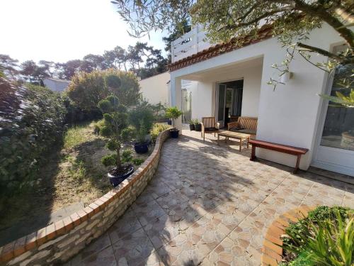 une terrasse d'une maison avec deux plantes en pot dans l'établissement Appartement 3 chambres 6 pers rez de Jardin 5min plage quartier du Phare Location du dimanche au dimanche en juillet et aout, à La Tranche-sur-Mer