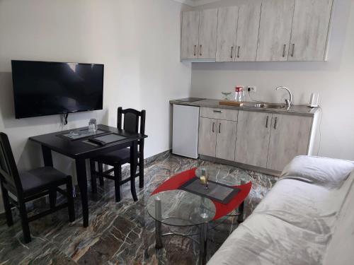 a living room with a couch and a table and a kitchen at Hotel Fama in Durrës