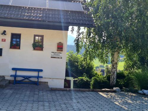 a blue bench sitting in front of a building at Apartma pri babici in Slovenj Gradec