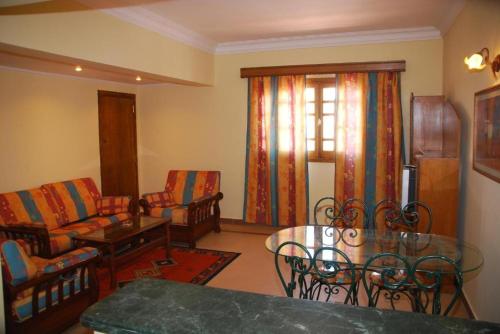 a living room with a couch and a table and chairs at Sharm al-Sheikh, Egypt - Hotel Apartment in Sharm El Sheikh