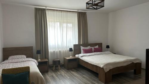 - une chambre avec 2 lits et une fenêtre dans l'établissement Casa de Vacanta Potoc, à Potoc