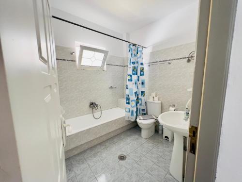 a bathroom with a tub and a toilet and a sink at Atrium Apartment #3 in Karpathos