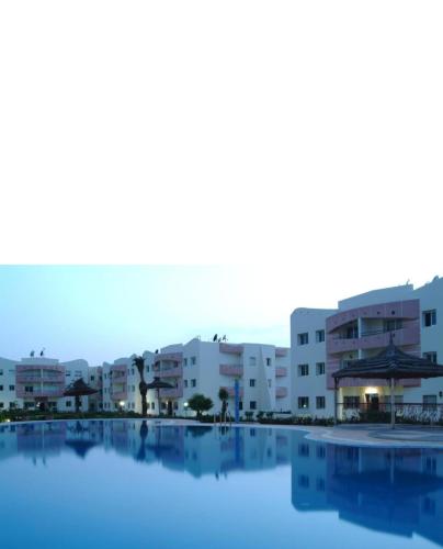 a pool in front of some apartment buildings at Les jardins de l'atlantique in Mohammedia