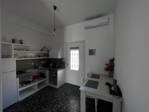 a white kitchen with a table and a counter top at suite diminutif l in Adamas