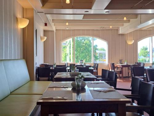 a restaurant with tables and chairs and a large window at Hotel Restaurant Boven Groningen in Delfzijl