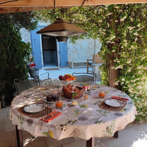 a table with a bowl of fruit on it at Le Ptit Cottage in Nyons