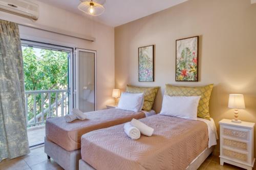 two beds in a bedroom with a balcony at Roxa seaview apartment in Agios Leon