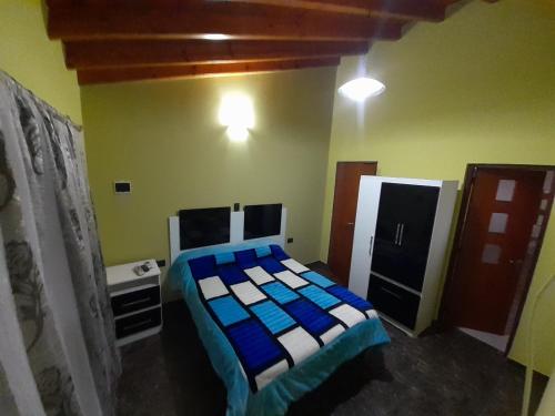 a bedroom with a bed with blue and white sheets at Hospedate en nuestro hogar y disfruta unas lindas vacaciones en Termas de Rio Hondo in Termas de Río Hondo