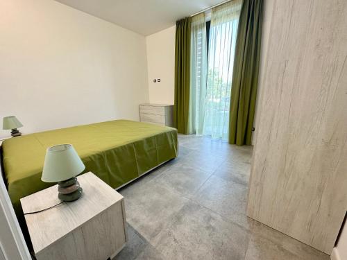 - une chambre avec un lit et une table avec une lampe dans l'établissement Lux apartments e, à Follonica