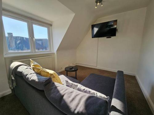 a living room with a couch and a flat screen tv at 2 bedroom Flat in Camden in London