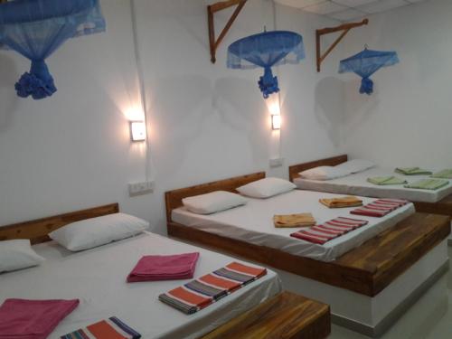 2 camas en una habitación con sombrillas azules en Italiano Safari House en Udawalawe