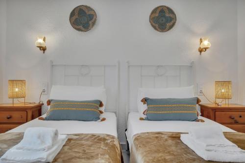 two beds in a room with two lamps on the wall at Casa del Limonero in El Tosalet