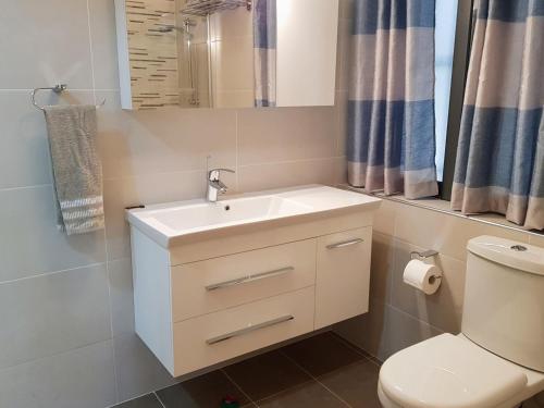 ein Badezimmer mit einem weißen Waschbecken und einem WC in der Unterkunft Charming apartment-wifi-sleeps 5 in Marsaskala