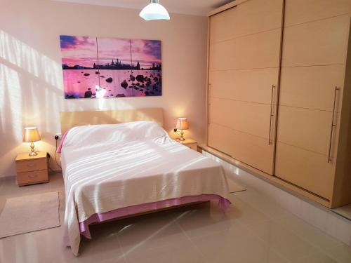 una camera da letto con un letto e un dipinto sul muro di Charming apartment-wifi-sleeps 5 a Marsaskala