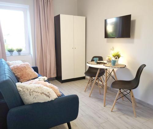 a living room with a blue couch and a table at Mini Apartamenty Poznań in Poznań