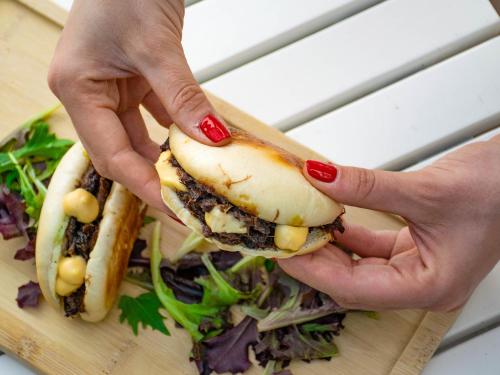 a person holding a sandwich on a cutting board at Hotel Plaza in A Coruña