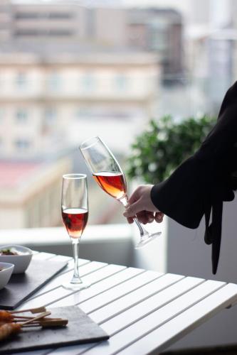 a person is holding a glass of wine on a table at Hotel Plaza in A Coruña