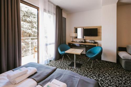 a hotel room with a bed and a desk and a window at Ośrodek Warszawianka in Świnoujście