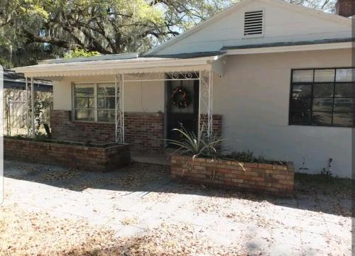 a home with a front porch and a brick house at Cheerful 3 bed 2 bath with Office, Patio, and Yard in Wildwood