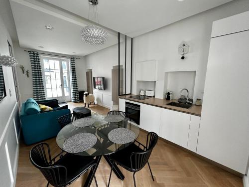 une cuisine et un salon avec une table et des chaises dans l'établissement Suite Clémenceau, à La Baule