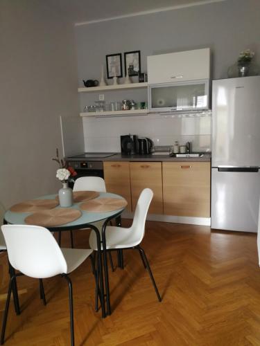 a kitchen with a table and chairs and a refrigerator at CENTRUM11 in Pécs