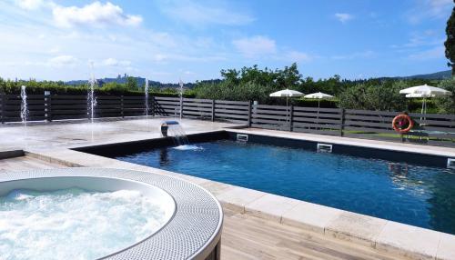 a swimming pool with a hot tub and a fountain at Villasanpaolo Resort & Spa in San Gimignano