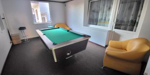 a room with a pool table and two chairs at ASIA- Pokoje Gościnne i Studia in Ostrowo