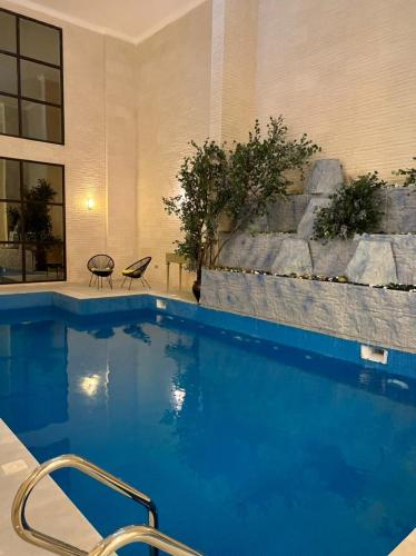 a swimming pool with blue water in a building at شالية مارينا مرباط in Mirbāţ