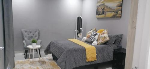 a bedroom with a bed with a yellow blanket at Lady D Exclusive Abode in Polokwane