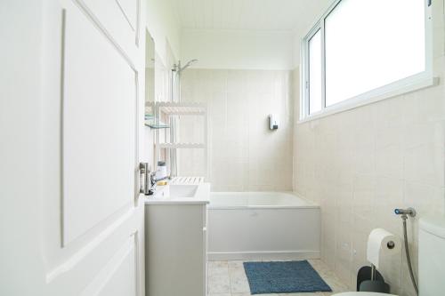 a white bathroom with a tub and a sink at Livramento Residence in Livramento