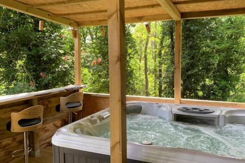 a hot tub in a gazebo with two chairs at Domaine de la Folicoeur in Sainte-Colombe-près-Vernon