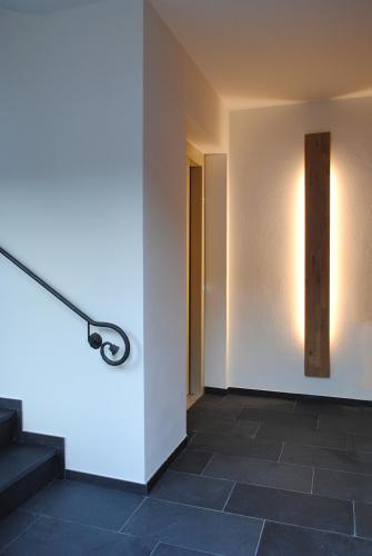 a hallway with stairs and a light on the wall at Landhaus Gräfendhron in Gräfendhron