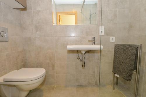 a bathroom with a toilet and a sink at Vivaldi Lake House in Meteliai