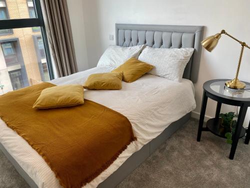 a bedroom with a bed with yellow pillows and a window at Stunning & Luxury Flat in Sutton