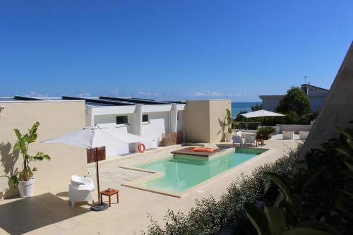 a house with a swimming pool and an umbrella at Dimore di Mare in Termoli