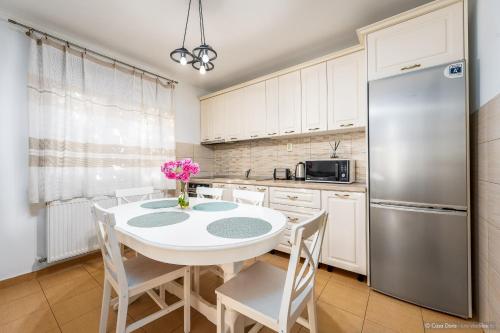 a kitchen with a table with chairs and a refrigerator at Casa Dora in Suceava