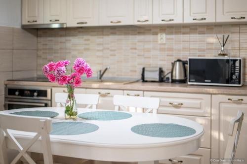 a kitchen with a table with pink flowers in a vase at Casa Dora in Suceava