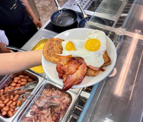 a plate of breakfast food with eggs and bacon at Hotel Bazzoni in Tremezzo