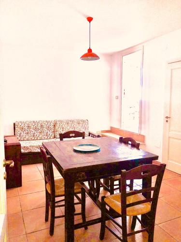 a dining table and chairs in a living room at Borgo Marino Plemmirio in Siracusa