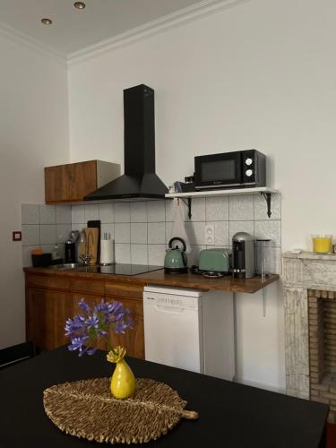 une cuisine avec une table avec un vase de fleurs dans l'établissement Studio dans un Château exceptionnel du 18è siècle, à La Londe-les-Maures