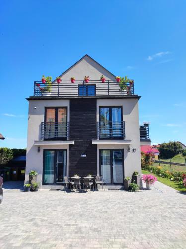 a house with tables and chairs in front of it at 4 Foxes in Ustka
