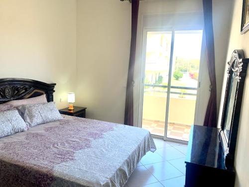 a bedroom with a bed and a sliding glass door at Bahia golf beach in Bouznika