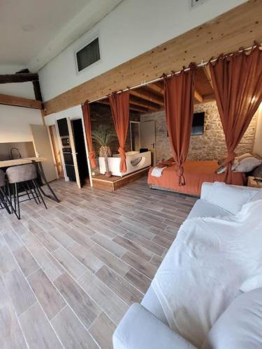 a living room with two beds and a table at Appartement cosy & piscine privée - Le Strelitzia in Vergèze