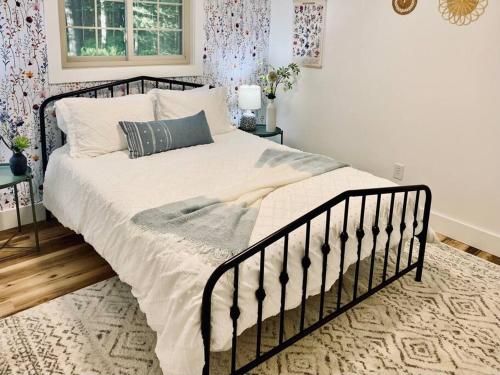 a bedroom with a large bed with white sheets and pillows at Chalet Retreat w/ Hot Tub, Short Walk to Lake & Pool in Jim Thorpe